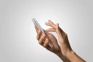Imagem de uma mão segurando um smartphone moderno, demonstrando a interação digital e a tecnologia móvel no cotidiano.